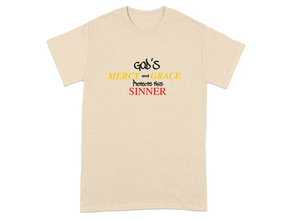 Light beige t-shirt with "GOD's MERCY and GRACE PROTECTS this SINNER" in yellow and red text.