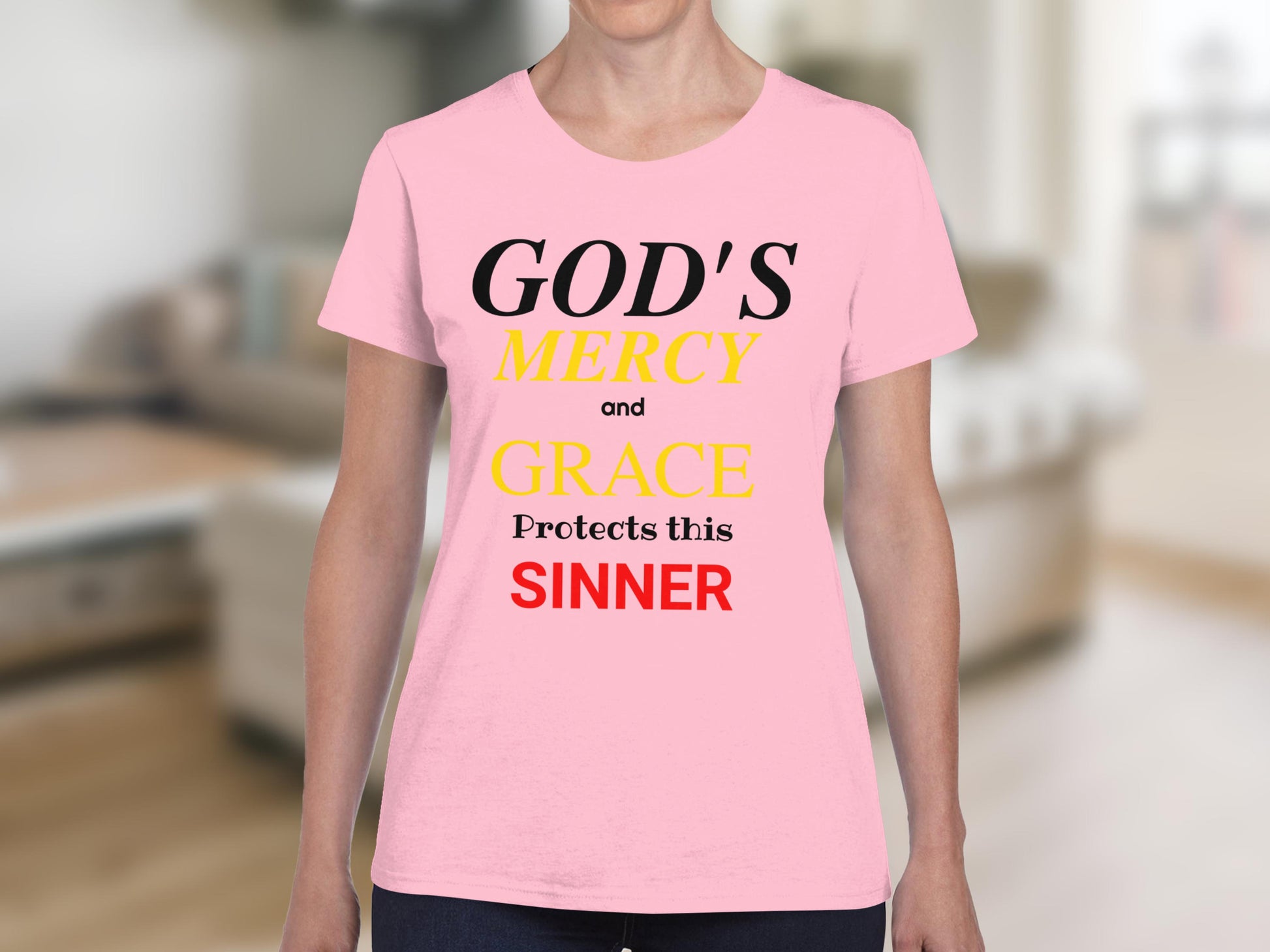Pink t-shirt with "GOD'S MERCY and GRACE Protects this SINNER" in black, yellow, and red text.